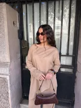 Conjunto gris melange compuesto por un buzo de cuello bote amplio y corte asimétrico con bolsillos, y un pantalón largo de corte recto y holgado.