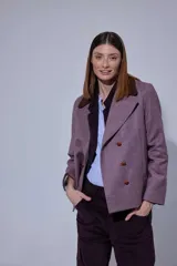 Chaqueta de paño con doble abotonadura, botones de cuero y cuello de piel sintética. Presenta un diseño de largo a la cadera con bolsillos verticales delanteros y forro interior.
