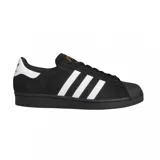 Championes adidas Superstar ADV, modelo clásico con puntera de goma, confeccionados en gamuza negra con las icónicas tres tiras laterales en blanco y detalle de logo dorado en la lengüeta.
