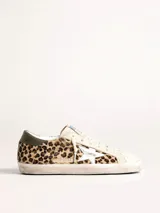 Zapatillas Golden Goose modelo Super-Star, con estampado animal print de leopardo, estrella plateada en el lateral y detalle verde en el talón.