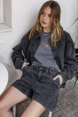 Campera de denim color negro con efecto lavado, corte semi oversize, cierre frontal completo, cuello camisero y bolsillos laterales.