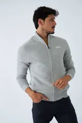 Campera tejida de algodón en color bordó, con cierre frontal completo, cuello alto y logo bordado en el pecho.