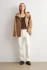 Trench color camel con capucha desmontable, cierre frontal con cremallera, bolsillos laterales y mangas largas con ajuste en puños.