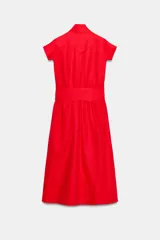 Vestido midi rojo de la colección ZW de Zara, confeccionado en hilatura con lino. Cuenta con escote en pico, manga corta, bolsillos laterales ocultos en la costura, falda de corte evasé y cierre frontal con cinturón ajustable del mismo tejido.