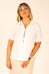 Camisa blanca de mangas cortas con cuello clásico y cierre frontal con botones.