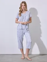 Conjunto de pijama marca René Rofé, compuesto por remera de manga corta con cuello redondo y aplique de puntilla, y pantalón capri con cintura elastizada, ambos en tejido soft estampado con motivos florales.