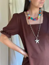 Collar corto con cuentas de cerámica, cristales checos y acrílico de diferentes colores y formas. Incluye una concha roja como dije central.