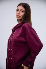 Sobrecamisa de gamuza en color violeta, con diseño de corte holgado, cuello camisero clásico, cierre frontal con botones metálicos a presión y dos bolsillos frontales tipo parche.