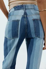 Jeans de tiro medio y pernera recta con diseño de rayas verticales en diferentes tonos de denim. Cuenta con cinco bolsillos y cierre frontal con cremallera y botón.