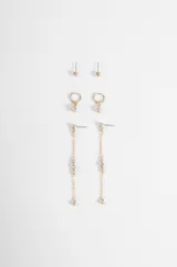 Set de tres pares de caravanas doradas con incrustaciones de strass. Incluye un par de abridores pequeños, un par de argollas con dije colgante y un par de caravanas largas con cadena y detalles de cristales.