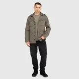 Chaqueta estilo militar de corte recto, color negro, con cuello camisero, cierre frontal oculto, charreteras en los hombros y cuatro bolsillos frontales con solapa.