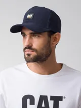 Gorra tipo trucker color azul marino con diseño de 5 paneles, visera curva y parte trasera de malla. Cuenta con un parche frontal con el logo de Caterpillar.