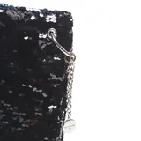 Bandolera negra cubierta de lentejuelas, con cadena plateada y cierre de broche. Forro interior textil y bolsillo interno con cierre.