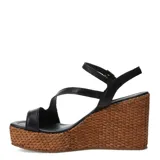 Sandalias de plataforma de corcho trenzado y taco chino, color suela, con tiras cruzadas de cuero y cierre de hebilla en el tobillo.