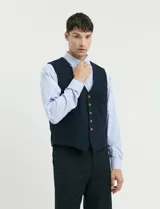 Camisa de manga larga con estampado de rayas verticales en azul y blanco, cuello clásico y bolsillo frontal.