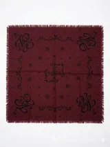 Bandana de lana color bordó con estampado gráfico en negro y bordes desflecados.