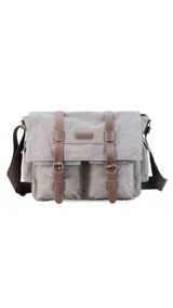 Morral de tela canvas color gris con detalles en cuero marrón, con tapa y doble bolsillo frontal, trasero y laterales. Interior espacioso con compartimento para notebook de 15". Correa de galón regulable para mayor comodidad.