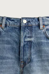 Shorts de denim de algodón con ajuste regular, diseño de cinco bolsillos y efecto lavado. Presenta cierre frontal con cremallera y botón, con el bajo acabado en corte irregular.