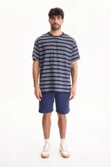 Remera oversize de manga corta confeccionada en algodón, con diseño de rayas horizontales en tonos azules y blancos.