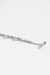 Collar de cadena de eslabones plateados con dijes en forma de corazón distribuidos a lo largo de la pieza. Cuenta con un cierre de barra en T.