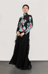 Polera de cuello alto y mangas largas, confeccionada en tela sublimada con estampado abstracto en tonos negro, verde, azul y rosa.