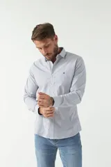 Camisa de manga larga para hombre, color blanco con microestampado de cuadros pequeños en azul. Presenta un corte slim, cuello camisero y un pequeño logo bordado en el pecho.