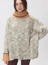 Pullover de punto jacquard color tostado con cuello alto y puños acanalados en tono azul y detalles en naranja. Cuenta con aberturas laterales y calce holgado.