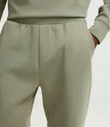 Pantalón deportivo de corte recto con ajuste levemente afunilado, confeccionado en tejido técnico con cintura elástica ancha. Presenta bolsillos laterales y bolsillo trasero embutido con acabado limpio.