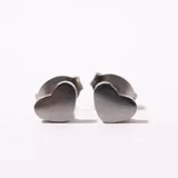 Par de aros pequeños plateados con forma de corazón.