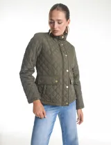 Campera de abrigo liviano con diseño capitoneado a rombos, cuello alto tipo mao y cierre frontal con solapa de botones a presión dorados. Presenta bolsillos frontales de parche con solapa y trabas de ajuste en la cintura.