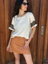 Remera negra de corte holgado con mangas cortas con volados y detalle de apliques de piedras en los volados.