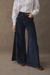 Pantalon de pana de corte wide leg, con tiro alto y costuras reforzadas en color contrastante. Presenta bolsillos delanteros y un diseño amplio y holgado.