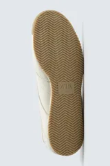 Zapatilla de estilo retro con cordones, confeccionada en una combinación de piezas de cuero sintético negro y detalles en blanco, con suela dentada de goma en tono caramelo.