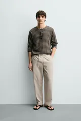 Pantalón de corte regular fit confeccionado en tejido mezcla de algodón, con cintura elástica ajustable mediante cordón, bolsillos laterales y bolsillos traseros de vivo.