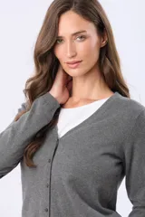 Saco tejido fino de hilo de algodón color beige, con cuello en V, cierre frontal con botones y puños acanalados.