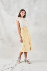 Blusa sin mangas color crema con bordado floral, cuello mao y volados en los hombros.