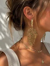 Caraganas colgantes doradas de diseño grande en forma de hoja con textura irregular y acabado brillante.