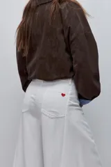 Pantalón wide leg de denim color blanco, de tiro alto y diseño clásico con perneras amplias.