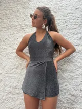Mono corto plateado con lurex, escote halter y corte cruzado en la falda.