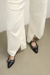 Pantalón de jean color crudo, de corte palazzo con aberturas en el ruedo y bolsillos laterales.