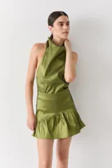 Top halter color marrón brillante, con cuello alto drapeado y espalda media baja.