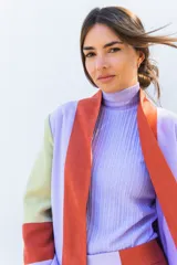 Chaqueta de corte recto con diseño multicolor en bloques de color naranja, lila y amarillo. Presenta cuello mao, mangas largas con puños vueltos y bolsillos laterales.