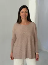 Sweater de punto color visón con diseño de trenzas horizontales, cuello redondo y mangas largas con puños acanalados.