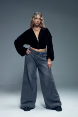 Canguro negro de terciopelo con mangas abullonadas, puños ajustados y cierre metálico frontal.