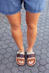 Sandalias bajas de cuero marrón con tres tiras: una de cuero marrón, una de cuero liso color visón y una de cuero con estampado animal print.