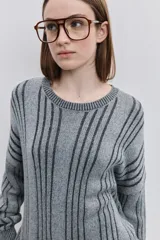 Sweater de punto color gris con diseño de rayas verticales oscuras, cuello redondo y calce relajado de mangas largas.