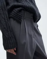 Pantalón sastrero pinzado gris, confeccionado en tela italiana, de tiro medio/alto y largo hasta los tobillos. Silueta baggy, cintura prearmada, cartera con cierre y botón, bolsillos laterales funcionales, doble pinza en cada pierna, pinzas en la espalda y bolsillo ojal con presilla y botón.