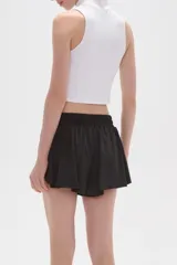 Short de poliéster color negro, de calce holgado y tiro alto, con cintura elástica y cordón ajustable.