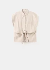 Camisa de lino y algodón color beige con estampado de raya diplomática, cuello camisero, manga corta y detalle de nudo en la cintura con cierre delantero de botones.