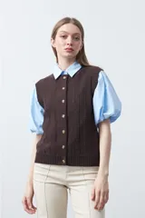 Chaleco tejido de punto color marrón oscuro, con botones frontales y diseño de punto calado vertical.